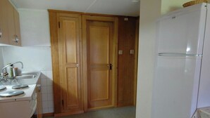 A kitchen with a refrigerator, a sink, and wooden cabinets. - Stockbrunä Appartement/Fewo, Bad, WC, 2 Schlafräume by Interhome (Adelboden)