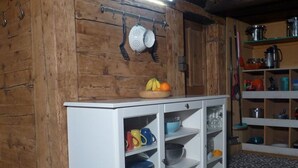 A kitchen with wooden walls, a white cabinet with glass doors, and a tiled floor. - Hami Appartement/Fewo, Dusche, WC, 3 Schlafräume Bauernhaus by Interhome (Adelboden)