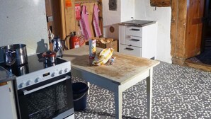 A compact kitchen with a stove, sink, and a small table with a bread loaf. - Hami Appartement/Fewo, Dusche, WC, 3 Schlafräume Bauernhaus by Interhome (Adelboden)