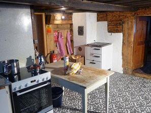 Eine kleine Küche mit Herd, Spüle und einem Tisch mit einem Brot.