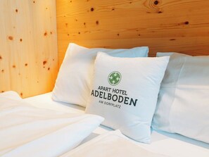 Ein Hotelzimmer mit einem hölzernen Kopfteil und weißer Bettwäsche.