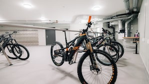 A bike storage area with multiple bicycles secured on racks. - KURVE Apartments & Lounge Appartement/Fewo, Bad, WC, 2 Schlafräume by Interhome (Adelboden)