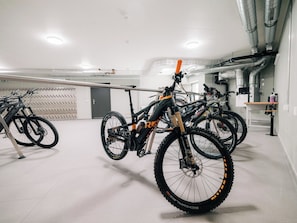 A bike storage area with multiple bicycles secured on racks. - KURVE Apartments & Lounge Appartement/Fewo, Bad, WC, 2 Schlafräume by Interhome (Adelboden)