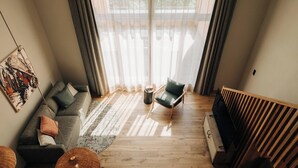 A modern living room with a sofa, armchair, and a TV stand. - KURVE Apartments & Lounge Appartement/Fewo, Bad, WC, 2 Schlafräume by Interhome (Adelboden)