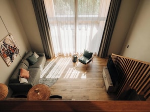 A modern living room with a sofa, armchair, and a TV stand. - KURVE Apartments & Lounge Appartement/Fewo, Bad, WC, 2 Schlafräume by Interhome (Adelboden)