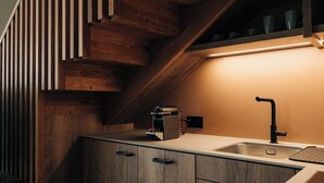 A kitchen with wooden cabinetry, a built-in oven, and a stainless steel sink. - KURVE Apartments & Lounge Appartement/Fewo, Bad, WC, 2 Schlafräume by Interhome (Adelboden)
