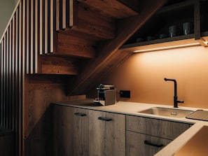 A kitchen with wooden cabinetry, a built-in oven, and a stainless steel sink. - KURVE Apartments & Lounge Appartement/Fewo, Bad, WC, 2 Schlafräume by Interhome (Adelboden)
