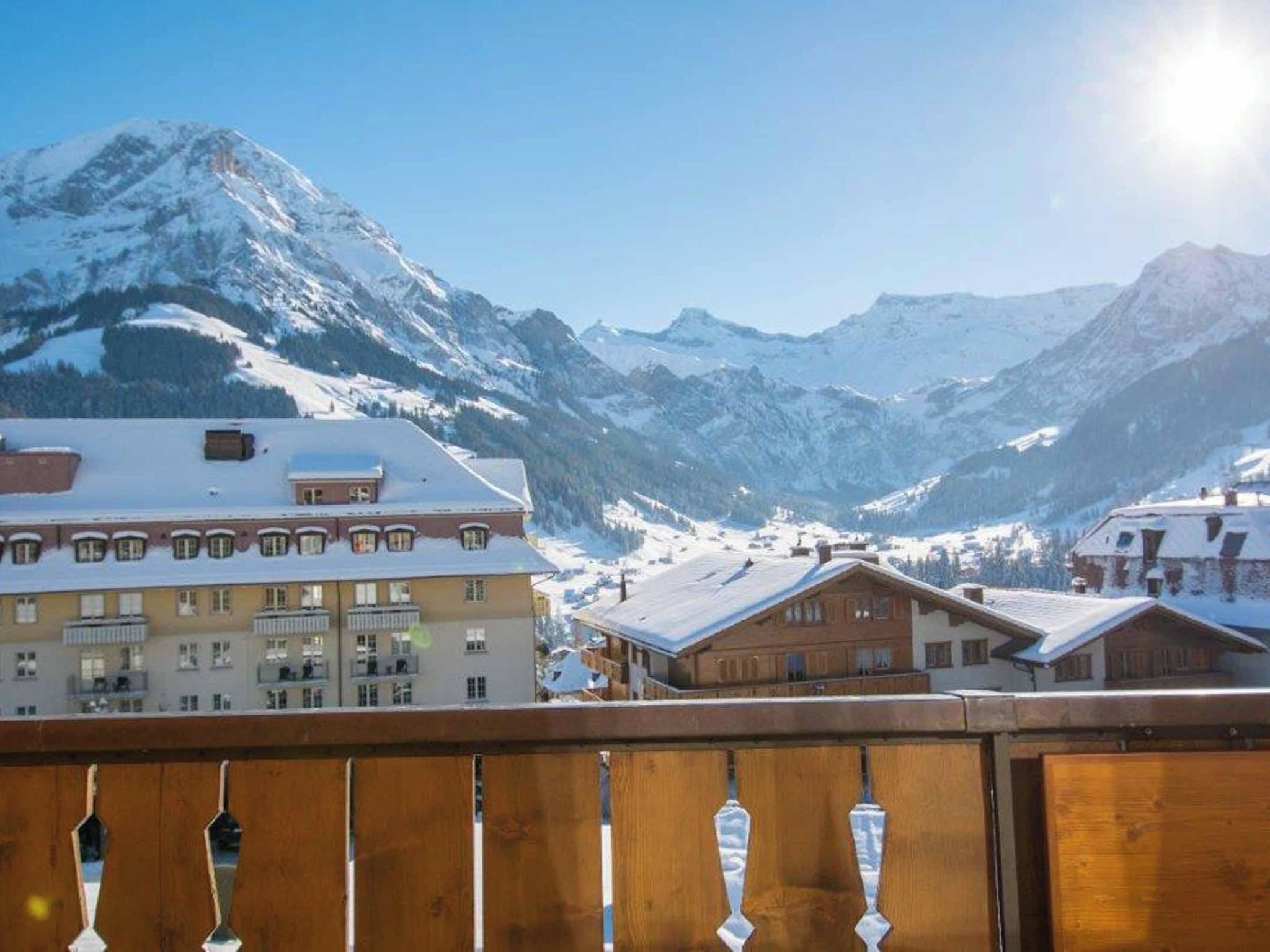 A mountain town with snow-covered buildings and a clear view of snow-capped mountains.