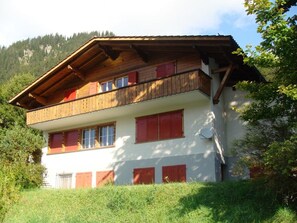 A two-story building with a wooden balcony, red shutters, and a white facade. - Chalet Buchhüttli Appartement/Fewo, Dusche oder Bad, WC, 2 Schlafräume by Interhome (Adelboden)