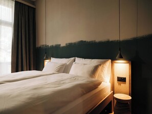A hotel room with a bed, bedside lamps, and a wooden nightstand. - KURVE Apartments & Lounge Appartement/Fewo, Bad, WC, 2 Schlafräume by Interhome (Adelboden)
