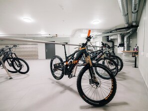 A bike storage area with multiple bicycles secured on racks. - KURVE Apartments & Lounge Appartement/Fewo, Bad, WC, 2 Schlafräume by Interhome (Adelboden)