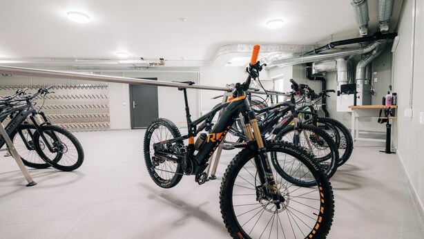 A bike storage area with multiple bicycles secured on racks. - KURVE Apartments & Lounge Appartement/Fewo, Bad, WC, 2 Schlafräume by Interhome (Adelboden)