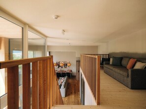A modern interior with a wooden staircase, a dining area, and a living room with a sofa. - KURVE Apartments & Lounge Appartement/Fewo, Bad, WC, 3 Schlafräume by Interhome (Adelboden)