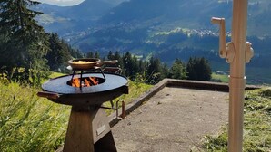 An outdoor cooking area with a grill, surrounded by a mountainous landscape and a clear sky. - Heuzündli Ferienhaus, Dusche, WC, 3 Schlafräume 4-Zimmer-Ferienhaus by Interhome (Adelboden)