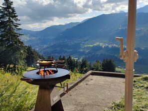An outdoor cooking area with a grill, surrounded by a mountainous landscape and a clear sky. - Heuzündli Ferienhaus, Dusche, WC, 3 Schlafräume 4-Zimmer-Ferienhaus by Interhome (Adelboden)