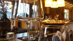 Eine Bar mit leeren Weingläsern und einer Kerze auf der Theke.