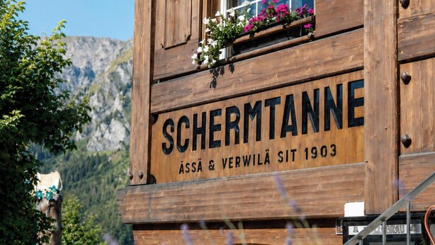 Ein Holzgebäude mit einem Schild, auf dem 'SCHERMTANNE' und das Jahr '1903' steht.
