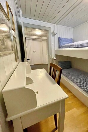 Ein Zimmer mit einem Etagenbett, einem Tisch und einem Stuhl.