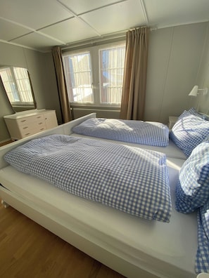 A single-bed room with a window, a bedside table, and a mirror. - Chalet Bärgli Appartement/Fewo, Bad, WC Chalet Bärgli – Ferienwohnung Gemmi by Interhome (Kandersteg)
