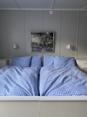 A bed with blue checkered bedding, a framed picture on the wall, and bedside lamps. - Chalet Bärgli Appartement/Fewo, Bad, WC Chalet Bärgli – Ferienwohnung Doldenhorn by Interhome (Kandersteg)