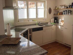 A kitchen with a granite countertop, a dishwasher, a stove, and a window with blinds. - Chalet Bim Stei Appartement/Fewo, Bad, WC, 2 Schlafräume 3-Zimmerwohnung by Interhome (Adelboden)