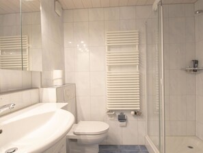 Un bagno moderno con vasca, WC e cabina doccia in vetro.