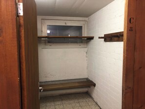 A narrow hallway with a wooden door, a window, and a small bench. - Akalei Appartement/Fewo, Dusche, WC, 3 Schlafräume 4.5-Zimmerwohnung by Interhome (Adelboden)