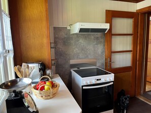 Eine kleine Küche mit eingebautem Herd, einem Toaster und einer Obstschale auf der Arbeitsfläche.
