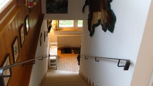 A staircase with a handrail, wooden walls, and various wall-mounted pictures. - Bärggeist, Gruebiweg 8, Adelboden Appartement/Fewo, Dusche und Bad, WC, 4 oder m by Interhome (Adelboden)
