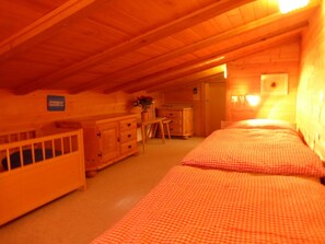 Ein Zimmer mit zwei Betten, einem kleinen Tisch und einem Schrank.