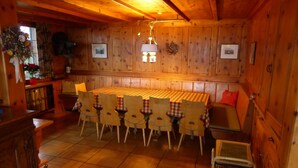 A wooden interior with a dining table and chairs, a bench, and a hanging light fixture. - Bärggeist, Gruebiweg 8, Adelboden Appartement/Fewo, Dusche und Bad, WC, 4 oder m by Interhome (Adelboden)