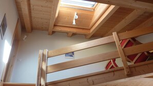 En trätrappa som leder upp till ett loft med ett takfönster.