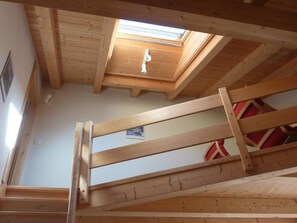 Eine Holztreppe führt zu einer Schlafgalerie mit einem Oberlicht.
