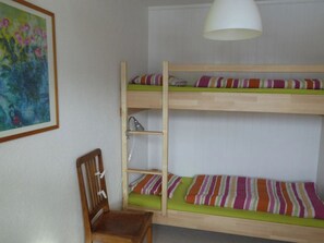 Ein Mehrbettzimmer mit Stuhl und Lampe.