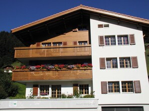 Un bâtiment à deux étages doté de balcons en bois et de jardinières.