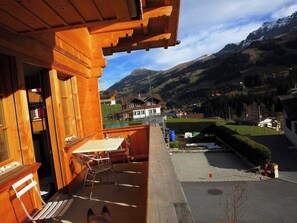 A wooden balcony with a table and chairs, overlooking a mountainous landscape with houses. - Mühleport Appartement/Fewo, Bad, WC, 1 Schlafraum 2.5-Zimmerwohnung by Interhome (Adelboden)