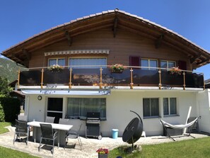 A two-story chalet with a balcony, outdoor seating, and a mountain view. - Aloa Appartement/Fewo, Bad, WC, 2 Schlafräume 3.5-Zimmerwohnung by Interhome (Adelboden)
