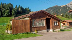A wooden cabin with a sloped roof, large windows, and a small porch. - Chalet Bondertal Appartement/Fewo, Dusche, WC, 2 Schlafräume 3.5-Zimmerwohnung by Interhome (Adelboden)