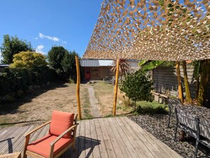 A wooden deck with a chair and a table, a pergola with a lattice design, and a building labeled 'LA SARDINE' in the background. - Townhouse near the train station (15-minute walk) and Sillon Beach (25-minute walk). Ideal Route du Rhum (Saint-Malo)