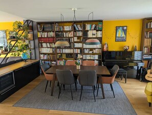A dining area with a wooden table and chairs, surrounded by bookshelves filled with books and decorative items. - Townhouse near the train station (15-minute walk) and Sillon Beach (25-minute walk). Ideal Route du Rhum (Saint-Malo)