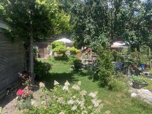 A garden with various plants and a tree. - Gartenstudio "Belle Vue" Appartement/Fewo, Bad, WC, 1 Schlafraum by Interhome (Frutigen)