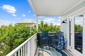 A balcony with a view of a house and greenery, featuring two chairs and a table. - Beach View.  Steps 2 Sand.  Remodel '26.  Sleeps 6 (Miramar Beach)
