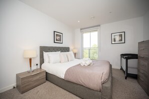 A bedroom with a bed, bedside tables, a dresser, and a window. - Comfortable 2BR apartment Deptford Yard, SE8 London - Pass the Keys (London)