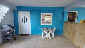 A room with a blue wall, a white door, a window, and a table with chairs. - Beach House Vega Alta PR (Sabana)