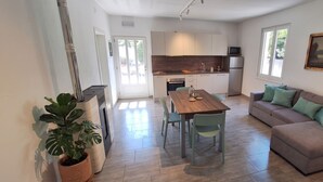 Une cuisine moderne avec un coin repas, un canapé et une plante en pot.