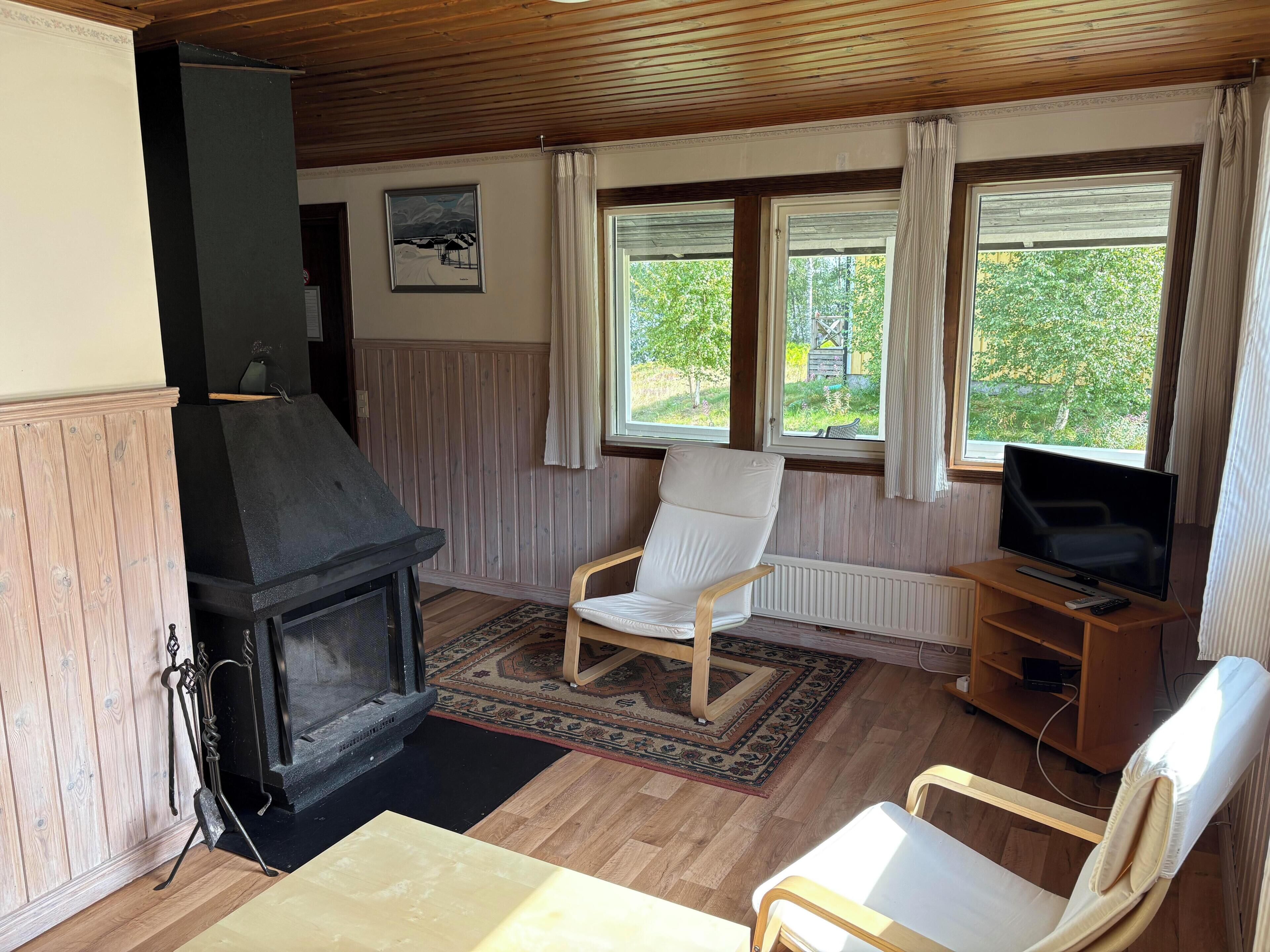 A room with a fireplace, a television, and a chair.