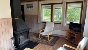Una sala de estar acogedora con chimenea, televisor y un sillón cómodo.