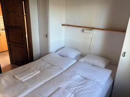 A single bed with white bedding and a wooden headboard.