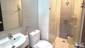 A bathroom with a toilet, sink, and shower.