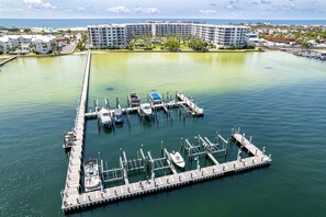A marina with several boats docked, a long pier, and a large hotel building in the background. - Beautiful Beachside Studio DW V504 (Fort Walton Beach)